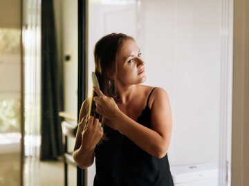 Frau kämmt sich die Haare | © Getty Images/Fiordaliso