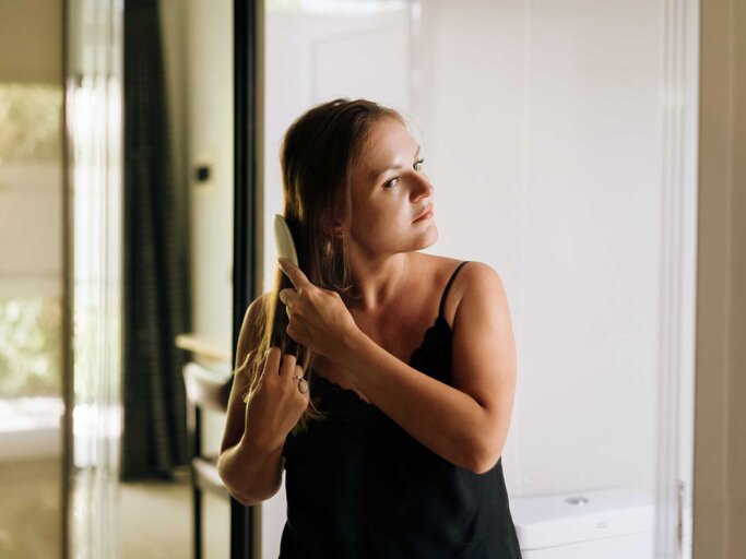 Frau kämmt sich die Haare | © Getty Images/Fiordaliso
