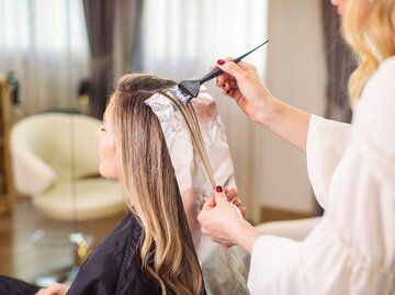 Frau bekommt Strähnen beim Friseur | © Getty Images/miljko