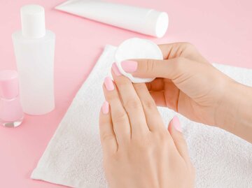 Frau entfernt Nagellack auf ihren Fingernägeln | © Adobe Stock/fotoduets
