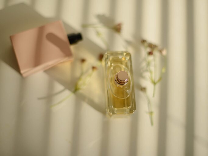 Parfums liegen mit Blumen zusammen | © Getty Images/Kristina Strasunske
