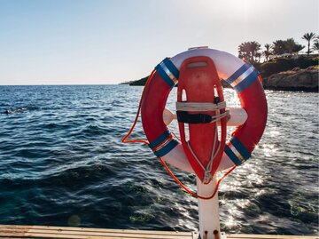 Rettungsring und -Brett an Strand | © Getty Images/Alex Walker