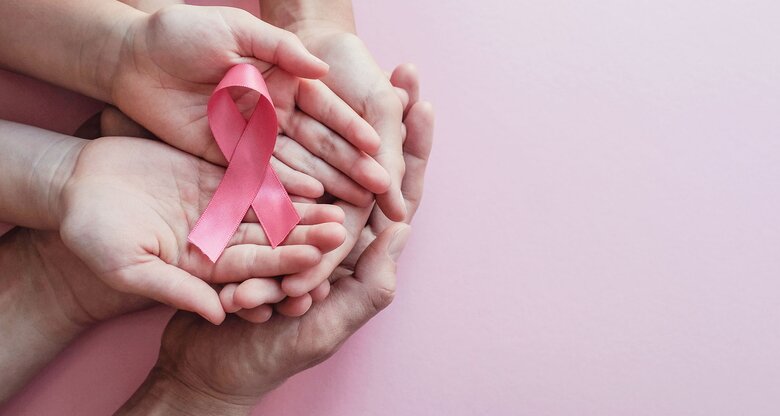 Hände von oben fotografiert, die eine pinke Schleife halten | © Adobe Stock/ SewcreamStudio