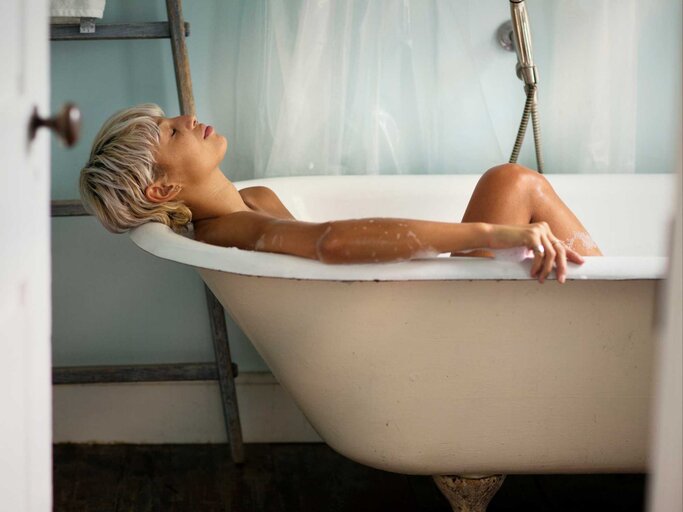 Junge Frau liegt entspannt in der Badewanne | © Getty Images/Cavan Images