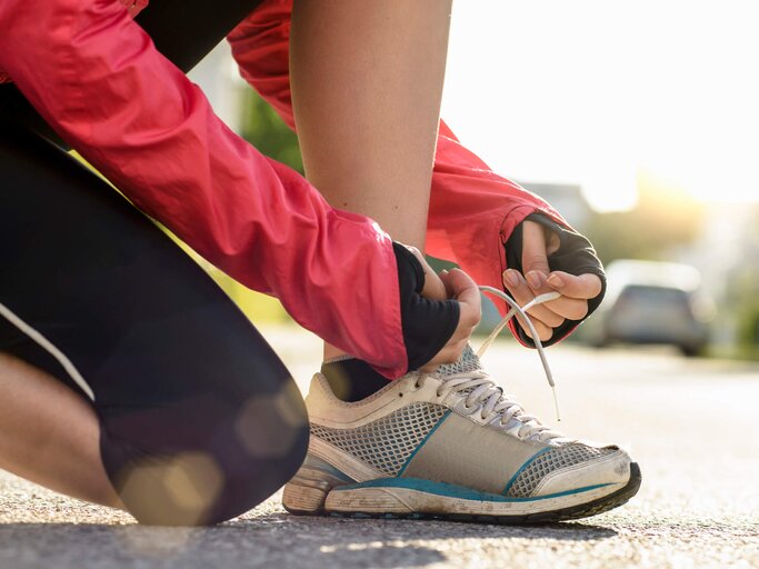 Frau bindet sich die Sportschuhe | © gettyimages.de /  Buero Monaco