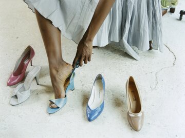 Frau probiert verschiedene Schuhe an | © Getty Images/Erica Shires