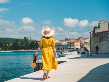 Frau im gelben Kleid am See | © Getty Images/Vera_Petrunina