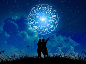 Personen umarmen sich und zeigen in Himmel mit Sternzeichenkreis | © Getty Images/sarayut Thaneerat