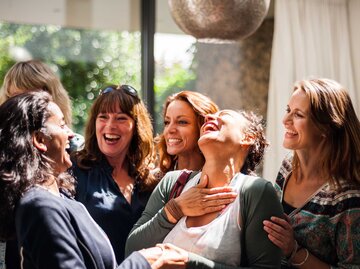 Eine Gruppe von Frauen steht zusammen und lacht. | © Getty Images / Lucy Lambriex