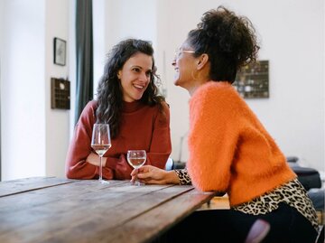 Zwei Personen sitze am Tisch mit Weingläsern | © Getty Images/Willie B. Thomas