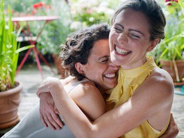Zwei Personen umarmen sich lachend | © Getty Images/Colin Hawkins