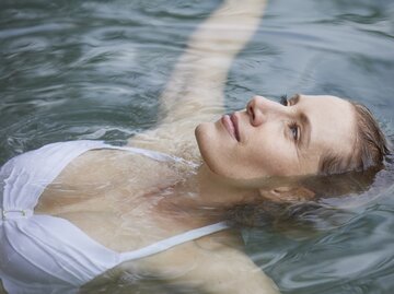 Frau liegt entspannt im Wasser  | © GettyImages/Westend61