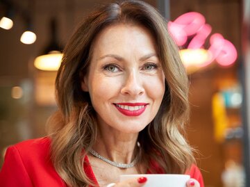 Frau mit roten Lippen lächelt in die Kamera. | © Getty Images / Westend61