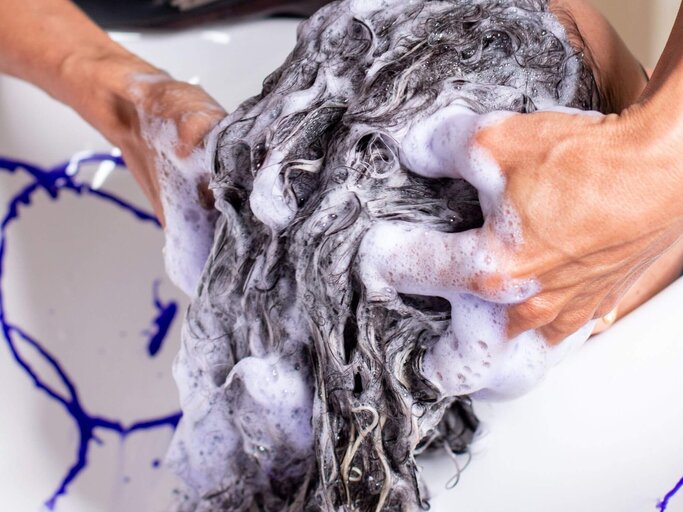 Person wäscht anderer mit Silbershampoo das Haar | © Getty Images/Anderson Piza