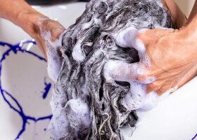 Person wäscht anderer mit Silbershampoo das Haar