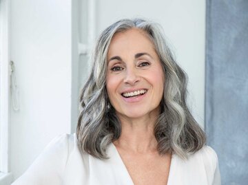 Frau mit grauen Haaren lächelt in die Kamera | © Getty Images/Westend61