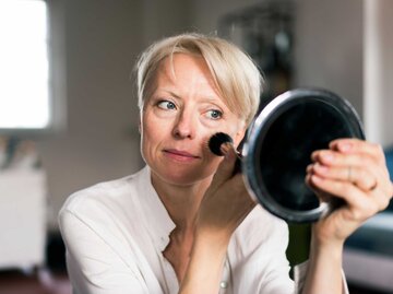 Frau schminkt sich mit Pinsel | © Getty Images/Westend61