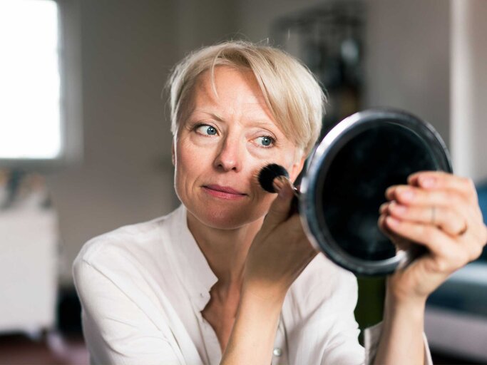 Frau schminkt sich mit Pinsel | © Getty Images/Westend61