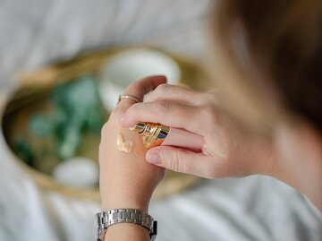 Eine Frau macht eine BB-Creme auf ihre Hand | © GettyImages/Emilija Manevska