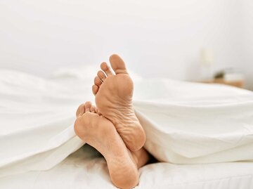 Füße im Bett | © Adobe Stock/Krakenimages.com