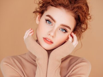 Eine Frau trägt schimmerndes Makeup | © GettyImages/CoffeeAndMilk