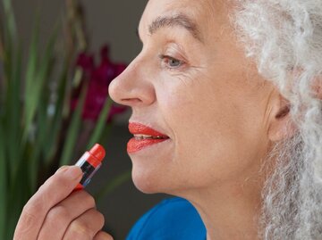 Person mit grauen Haaren trägt Lippenstift auf | © Getty Images/Tara Moore