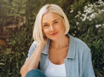 Frau in ihren 40ern draußen in der Natur mit einer Bob-Frisur | © Getty Images/knape