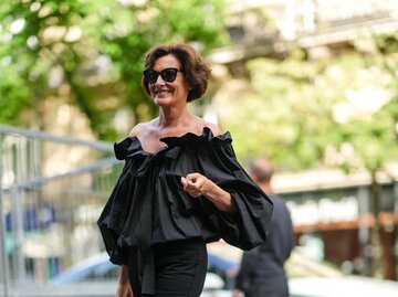 Ines de la Fressange trägt einen kurzen, stufigen Bob und ein schwarzes Outfit. | © Getty Images / Edward Berthelot