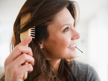 Person bürstet sich die Haare | © Getty Images/Jamie Grill