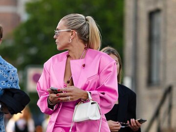 Eine blonde Frau mit pinkem Outfit trägt einen hohen Ponytail. | © Getty Images / Edward Berthelot