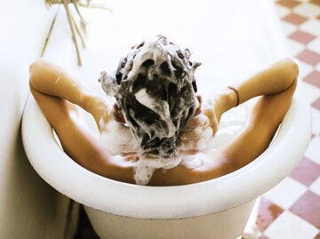 Person shampooniert sich Haare in Badewann | © Getty Images/PhotoAlto/John Dowland