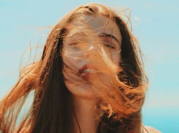 Junge Frau mit wild umher fliegenden Haaren | © Unsplash/Josh Parsons