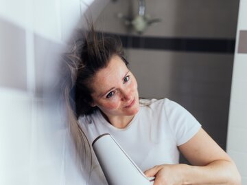 Eine Frau föhnt sich die Haare | © GettyImages/Guido Mieth