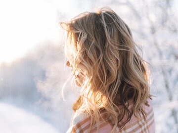 Frau mit blonden Locken in winterlicher Landschaft | © AdobeStock/Galina Zhigalova