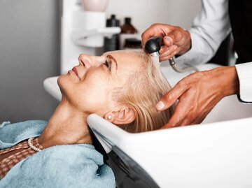 Person wird Haare gewaschen beim Friseur | © Getty Images/Nastasic