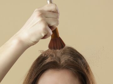 Frau pinselt Puder auf Haaransatz | © AdobeStock/triocean
