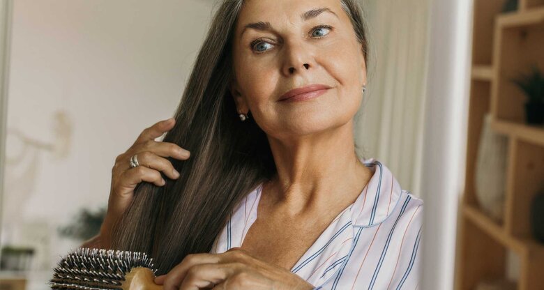 Ältere Frau kämmt sich die Haare | © Adobe Stock/shurkin_son