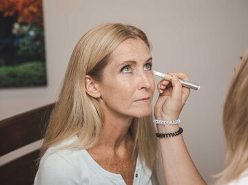 Frau werden Augenschatten mit Concealer abgedeckt. | © Getty Images/vitapix