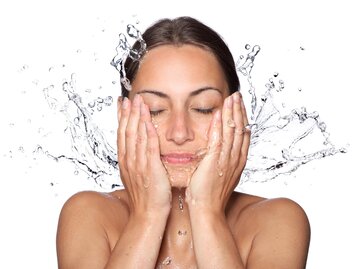 Frau wäscht sich Gesicht mit Wasser  | © AdobeStock/vitCOM