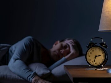Person im Bett schläft schlecht | © Getty Images/Filmstax