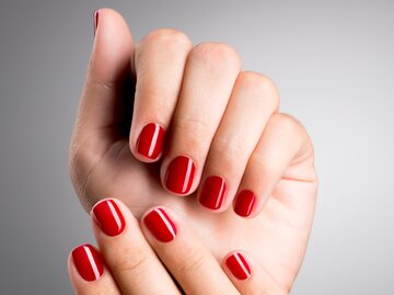 Hände mit kurzen, rot lackierten Nägeln | © Getty Images/ValuaVitaly