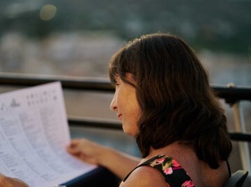 Frau schaut auf eine Speisekarte | © Getty Images/aire images