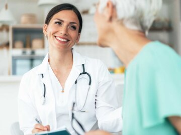 Junge Ärztin unterhält sich mit Patientin | © Getty Images/filadendron