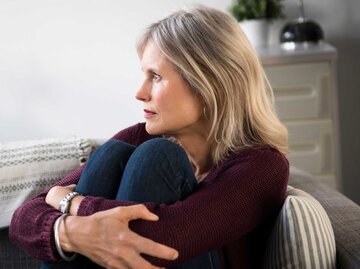 Reife Frau schaut nachdenklich aus dem Fenster | © Getty Images/JGI/Jamie Grill