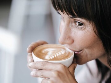 Frau trinkt einen Cappuccino.  | © Getty Images / Westend61