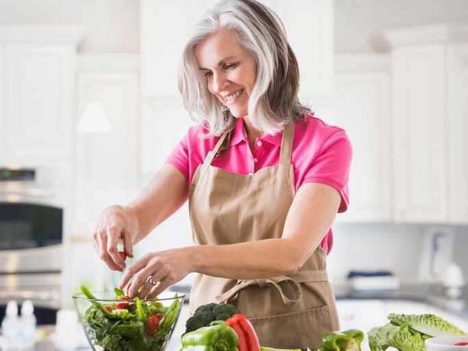 Frau bereitet einen Salat zu | © Getty Images/Mike Kemp