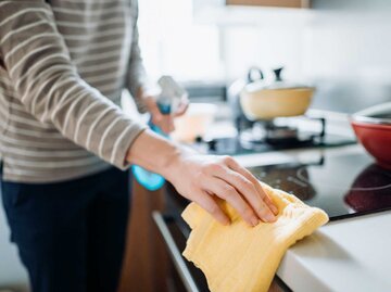 Frau putzt die Küche mit einem Waschlappen | © Getty Images/d3sign