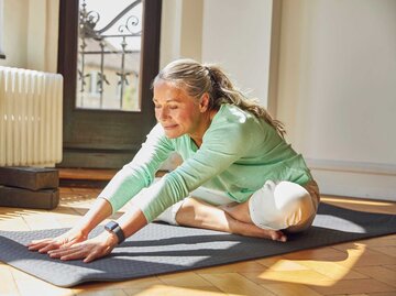 Ältere Frau macht Dehnübungen auf einer Yogamatte | © Getty Images/Westend61