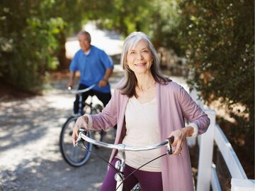 Lächelndes älteres Paar beim Fahrrad fahren | © Getty Images/Paul Bradbury
