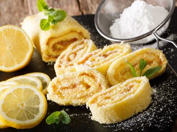 Hausgemachter Zitronenkuchen mit Fruchtcreme, dekoriert mit Minze und Puderzucker | © Getty Images/ALLEKO